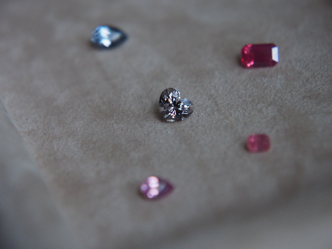 Five different colour spinels placed on top of a velvet beige tray