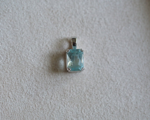 Carolyn Radiant aquamarine pendant in front of a beige background