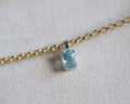 Carolyn Radiant aquamarine pendant in front of a beige background with chain