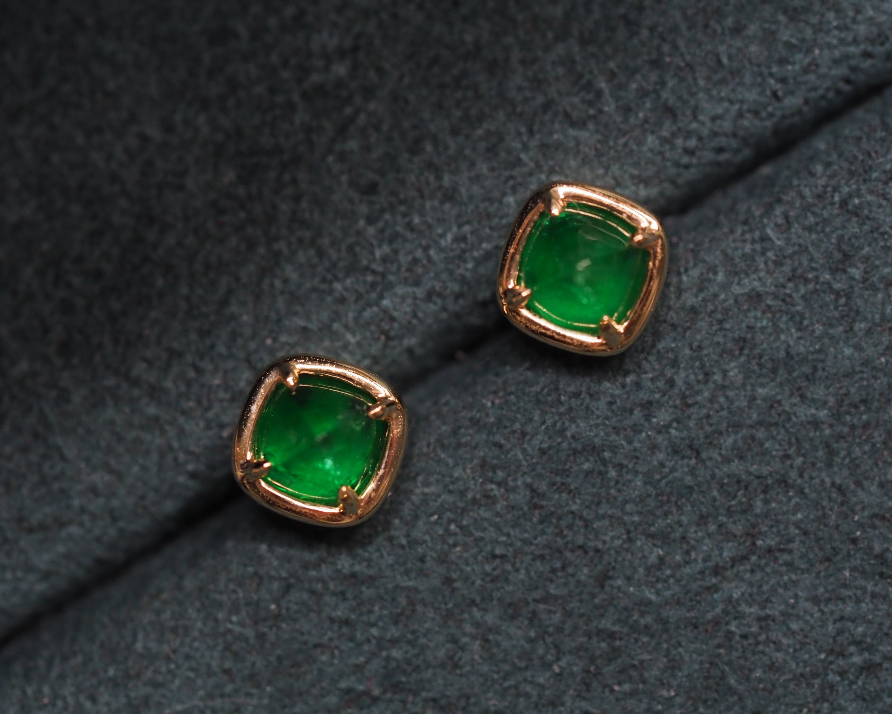Elizabeth emerald studs on top of a green velvet background 