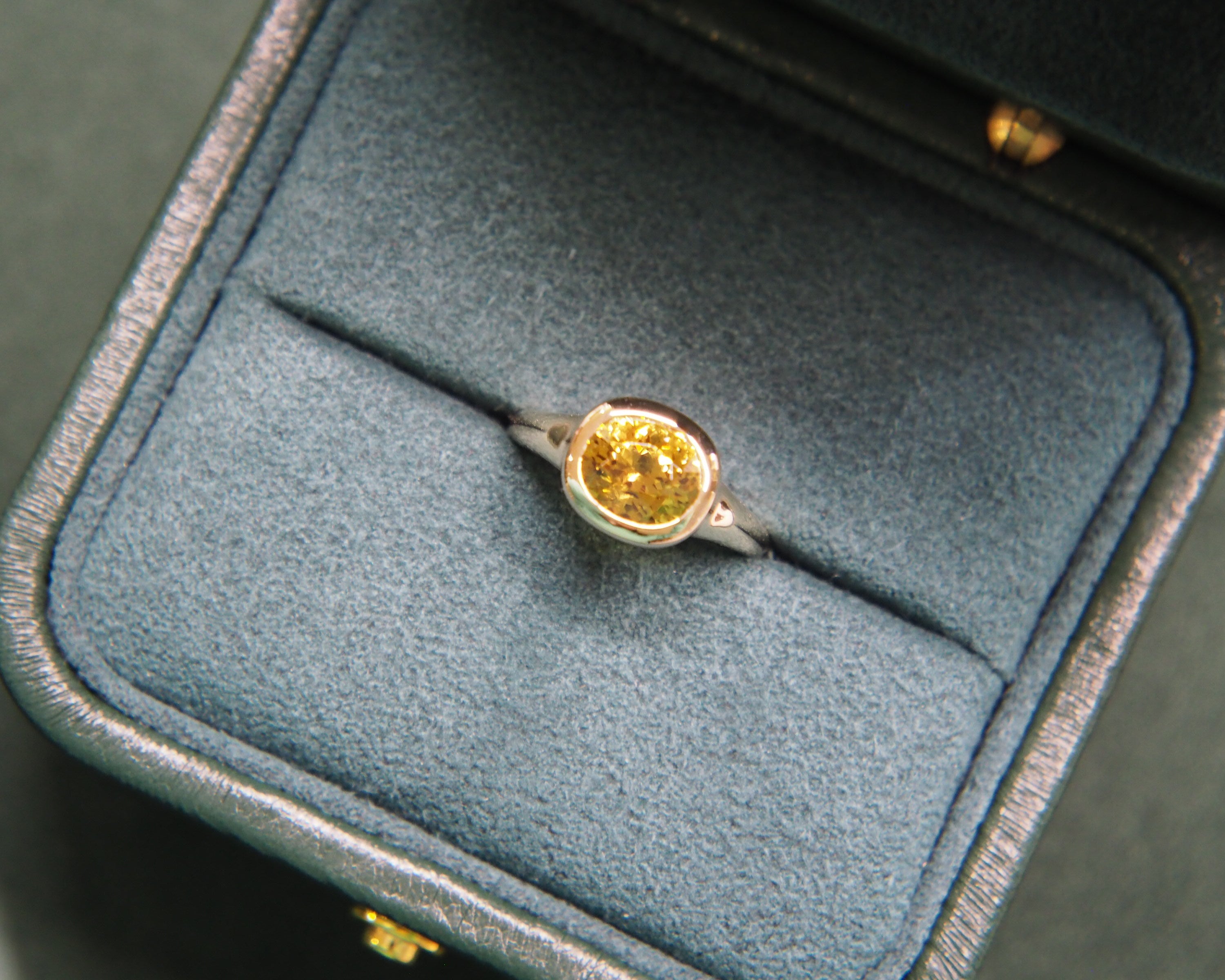 Gold ring with a yellow gemstone in a jewelry box