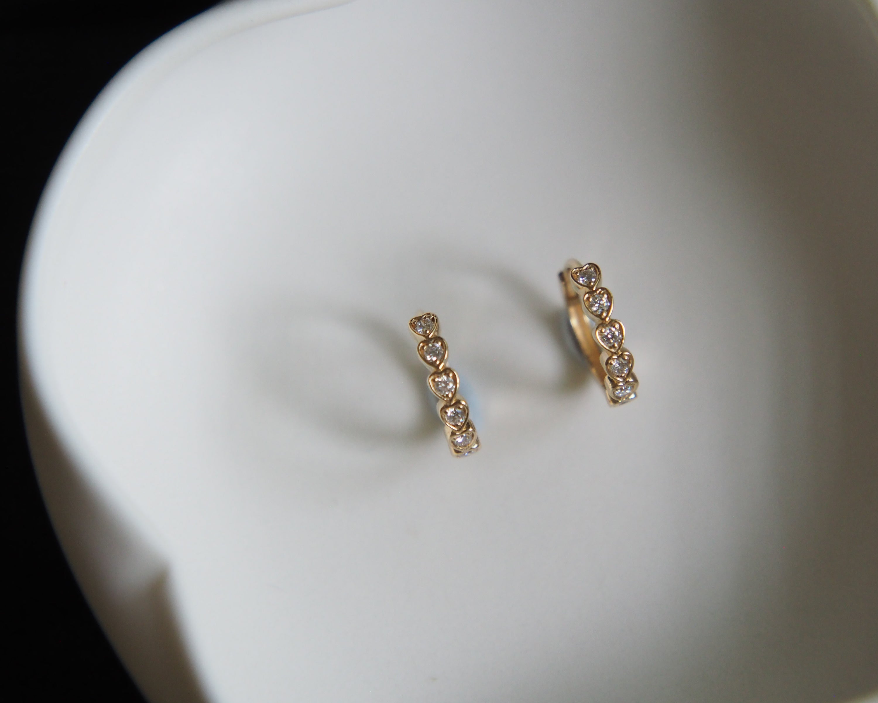 Pair of gold hoop earrings on a white surface
